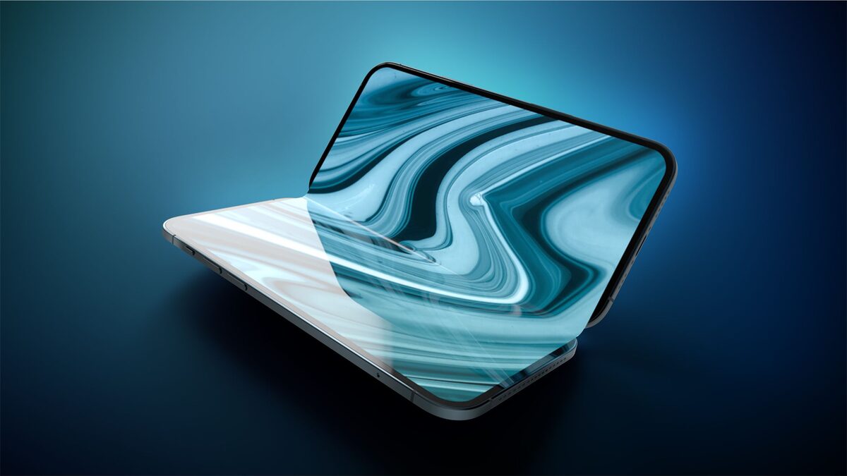 A concept render of a foldable iPhone open on a desk, showing the interior display and hinge mechanism.