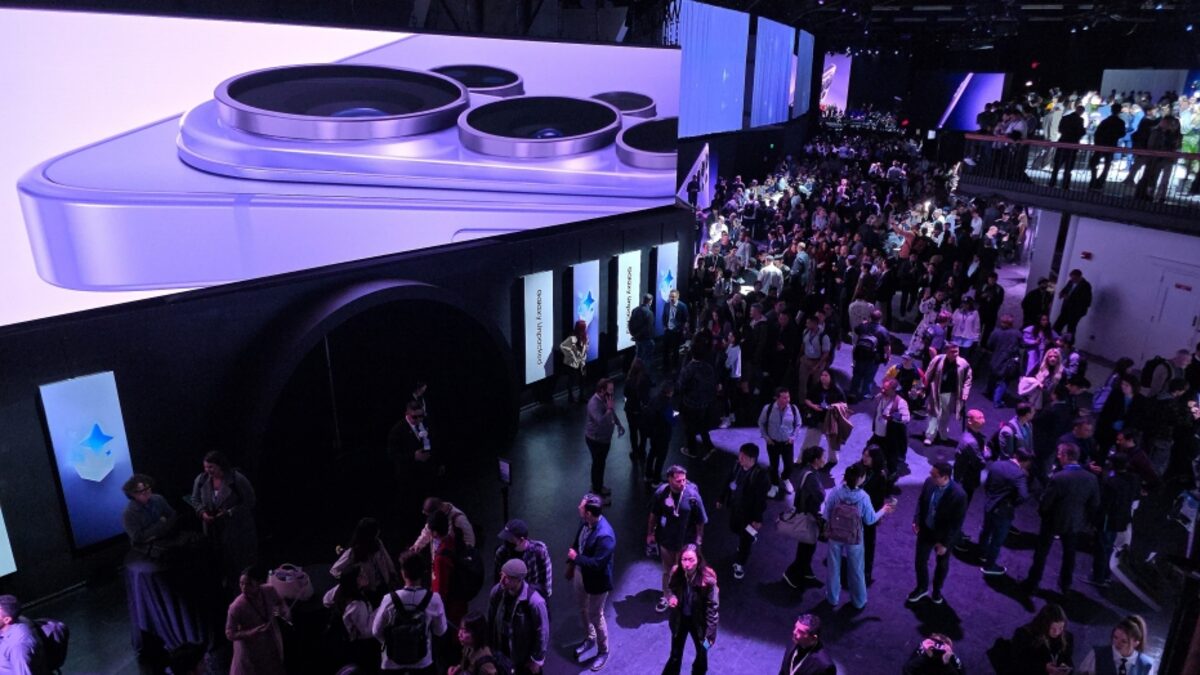 Crowd at Samsung Galaxy Unpacked 2026 below a giant screen showing the Galaxy S26 camera array